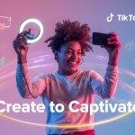 A joyful creator filming with a smartphone and ring light surrounded by glowing TikTok colors, symbolizing how short-form videos drive engagement and brand awareness.