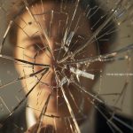 A glowing brand logo emerging from shattered glass, symbolizing reputation recovery, renewed trust, and brand transformation.