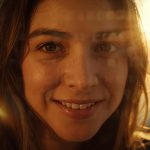 A smiling person speaks on camera with glowing text overlays of story fragments, symbolizing how authentic storytelling connects emotionally with audiences.