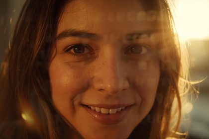 A smiling person speaks on camera with glowing text overlays of story fragments, symbolizing how authentic storytelling connects emotionally with audiences.