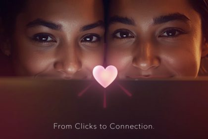 A marketer smiling at a glowing laptop screen showing a digital heart icon, symbolizing how small customer interactions can build lasting loyalty and brand love.