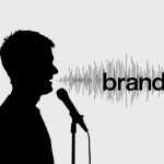 A creative designer visualizing a brand’s sound identity through colorful waveforms and a glowing microphone, symbolizing sonic branding.