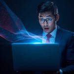 A marketer looks amazed at a laptop as holographic data shapes an email greeting, symbolizing AI-powered CRM personalisation in 2025.