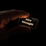 Person pressing “Allow Messages” button on phone screen