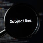 Person peeking from behind an email envelope in curiosit