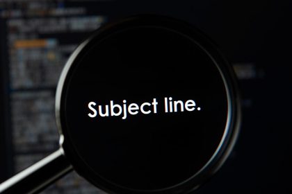 Person peeking from behind an email envelope in curiosit