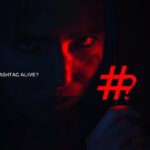 Person holding a large hashtag symbol, looking curious