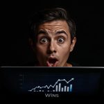 Marketer reacting with surprise while pointing at an AI dashboard showing customer LTV predictions and upsell growth.