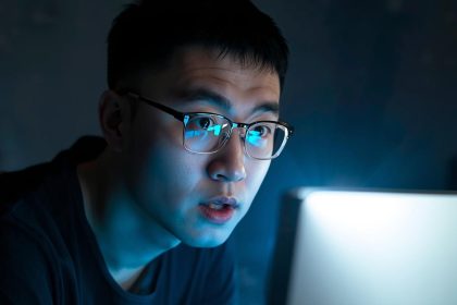 Creative professional collaborating with AI on a laptop, surprised expression, representing human-AI creative collaboration.