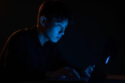 Person with a bold, expressive face illuminated by neon lights, pointing upward with confidence, symbolizing the power of a Social Media Micro-Branding Strategy.
